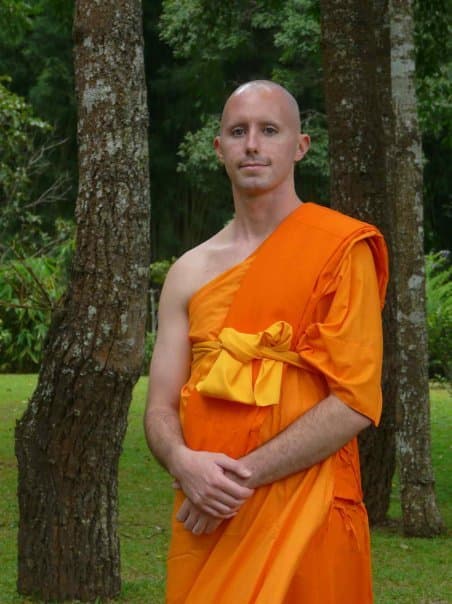 Sean Fargo as a Buddhist monk in the Thai Theravada tradition, contemplative pose in monastery forest